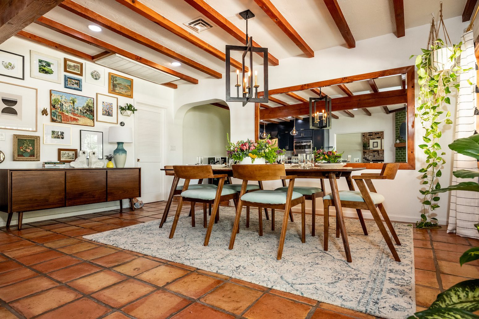 Dining room with wooden beams, gallery wall, and rustic furniture