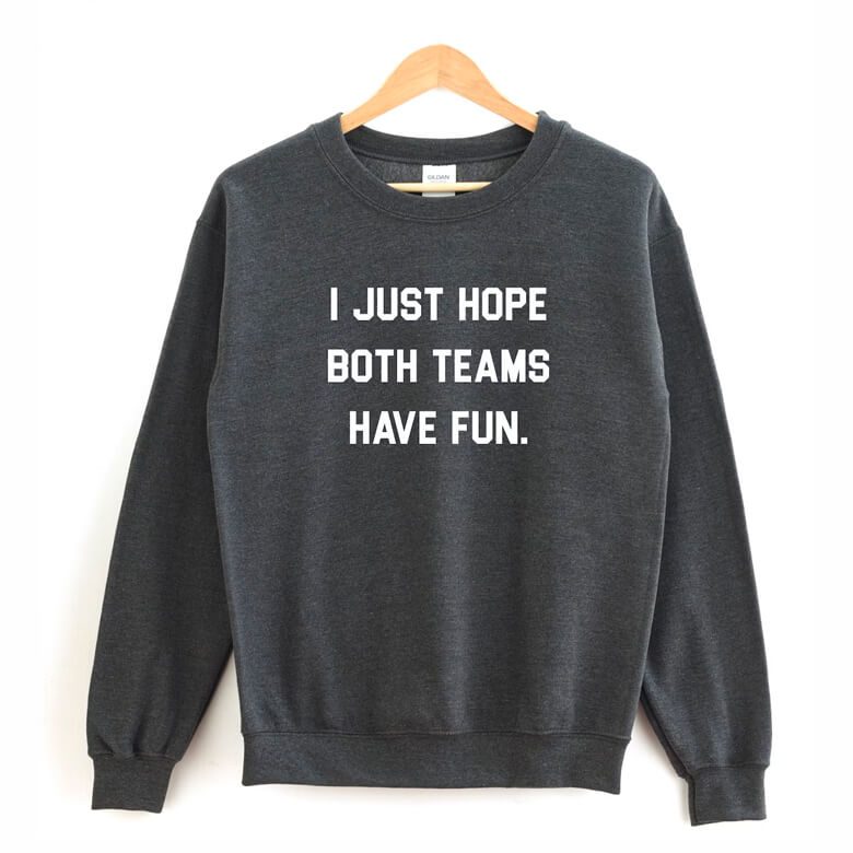 Dark gray sweatshirt on a hanger with white text that reads, "I JUST HOPE BOTH TEAMS HAVE FUN."