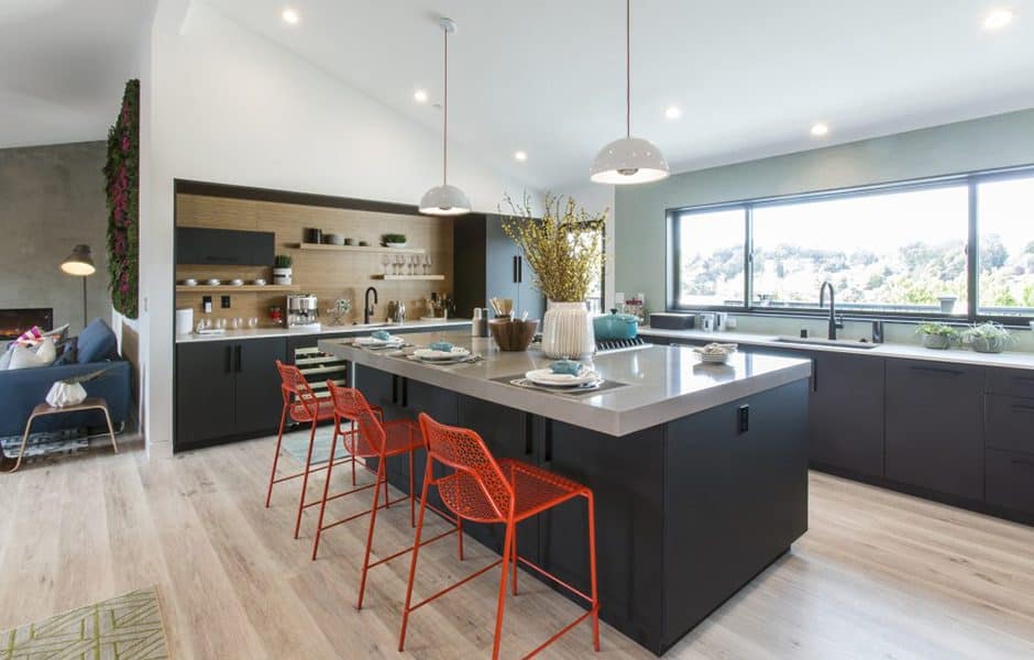 Spacious kitchen with black cabinetry, a large island, red barstools, and open shelving