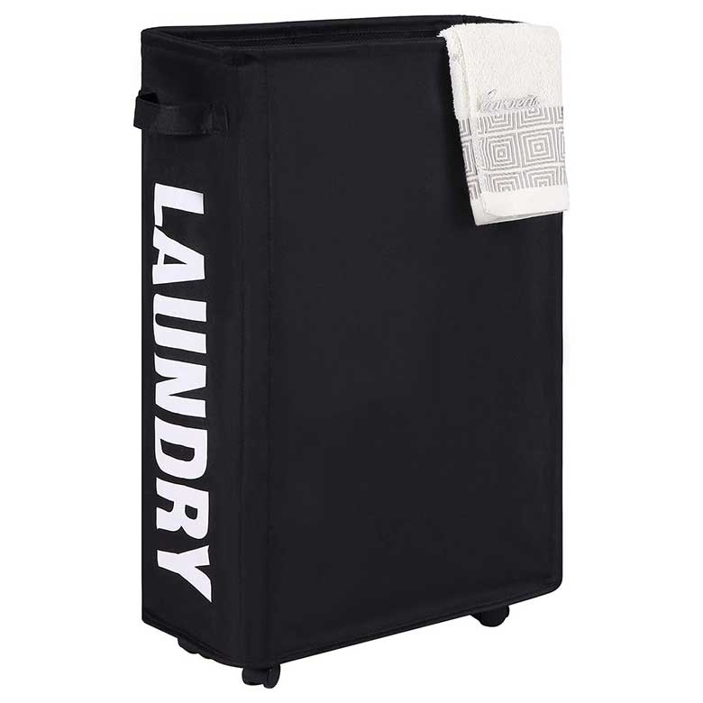 Black laundry hamper with wheels, white lettering on the side, and a folded towel draped over the top