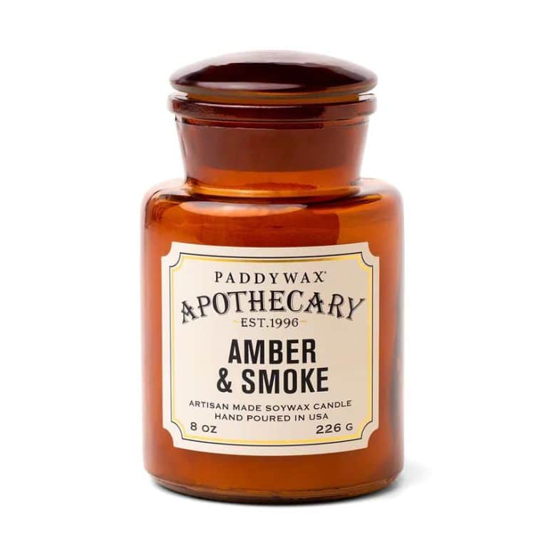 Amber glass jar candle labeled "Paddywax Apothecary Amber & Smoke."