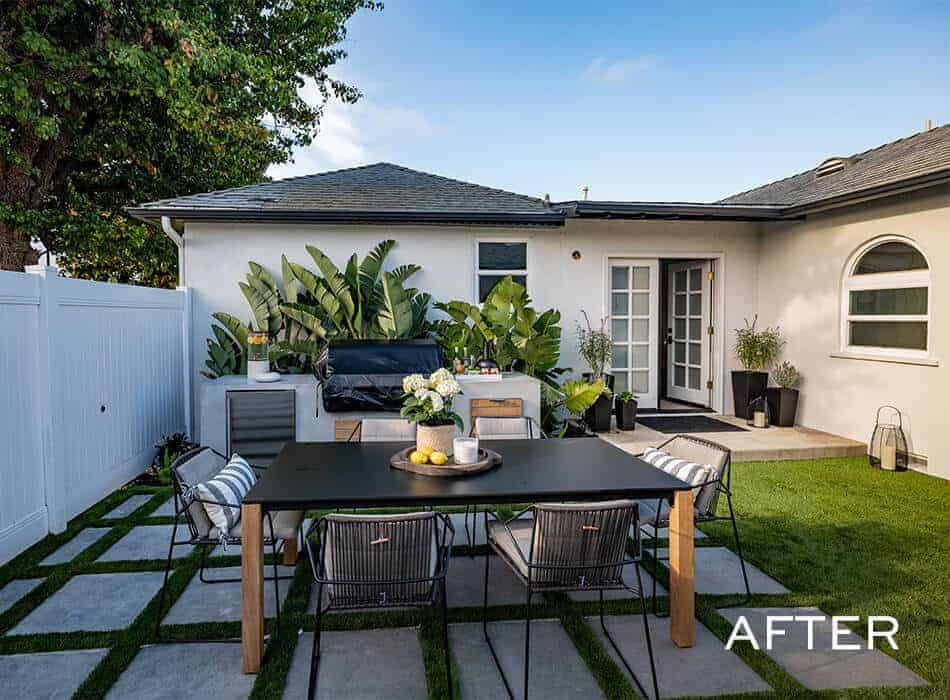 Modern backyard patio with outdoor dining table, chairs, built-in grill, and lush greenery