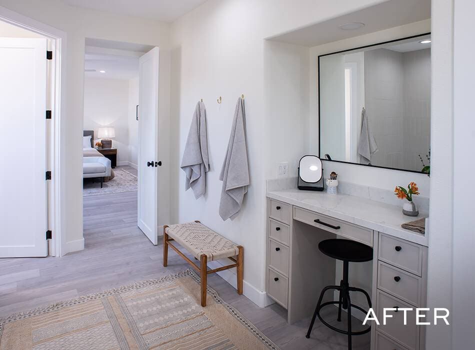 Vanity area with mirror and stool leading to a bedroom