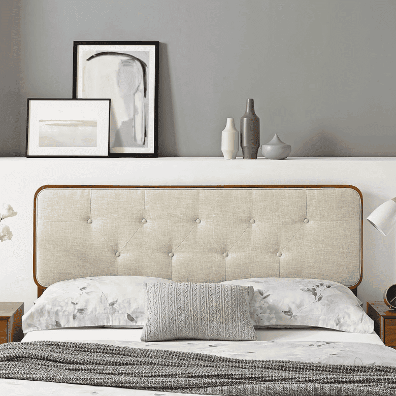Bed with beige tufted headboard, gray bedding, and minimalist decor accents