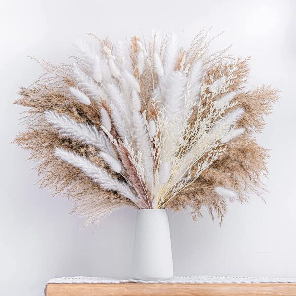 White vase filled with a large arrangement of dried pampas grass and soft white botanicals