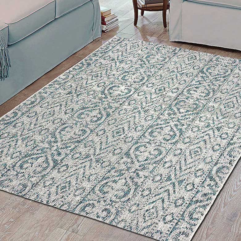 Textured area rug with intricate blue and white pattern on wooden floor