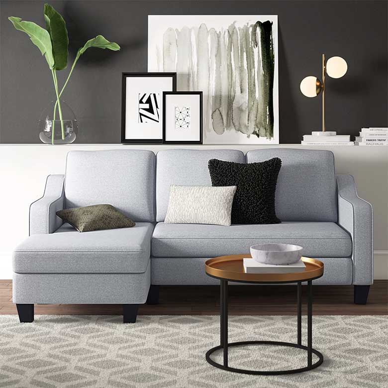 Modern living room with light gray sectional sofa, round coffee table, and abstract wall art