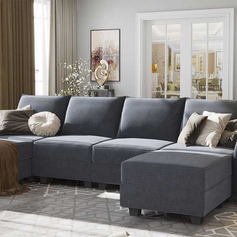 Living room with a dark gray sectional sofa, neutral throw pillows, and decorative wall art near French doors