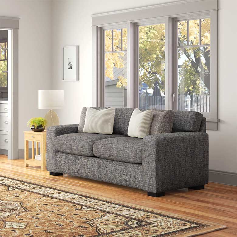Modern room with gray sofa and colorful area rug.