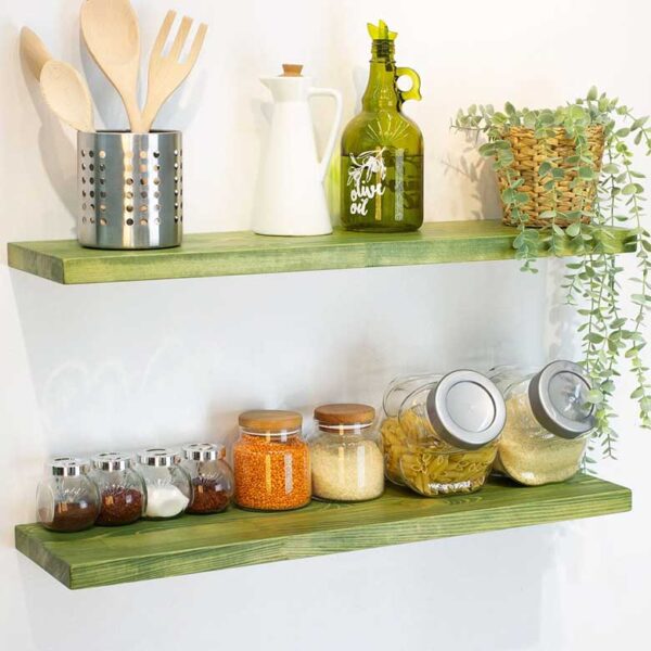 Green kitchen shelves with jars, utensils, and decor