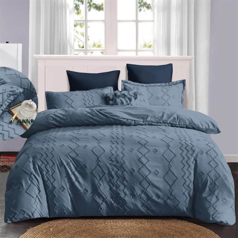 Blue geometric comforter set on white bedframe with navy accent pillows