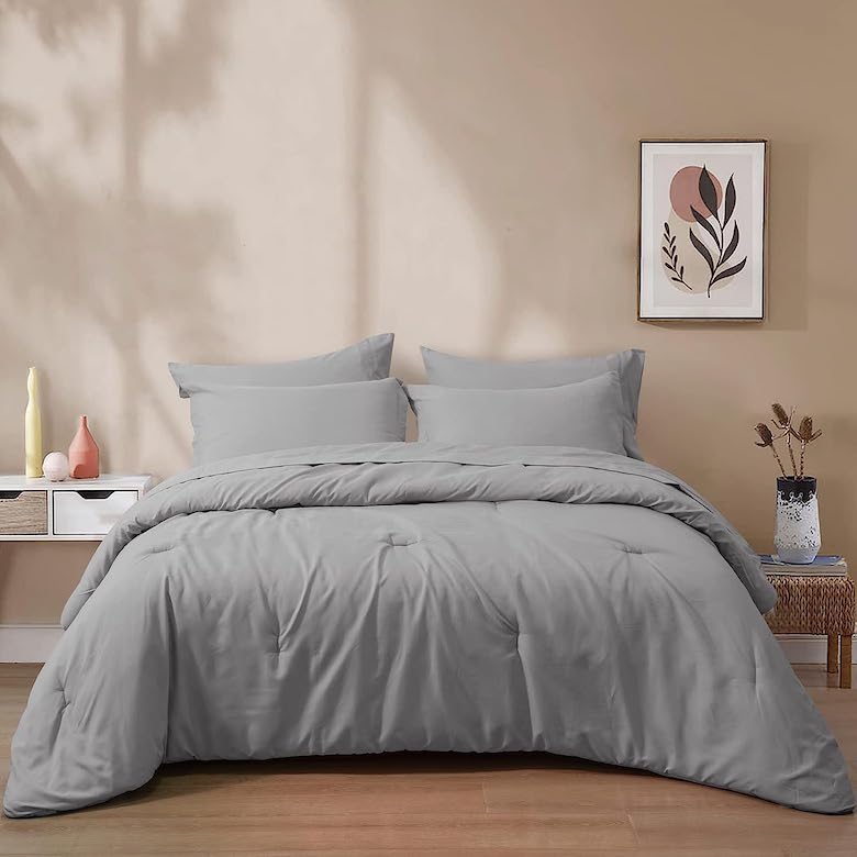 Bedroom with gray bedding beige walls minimalist decor and framed artwork