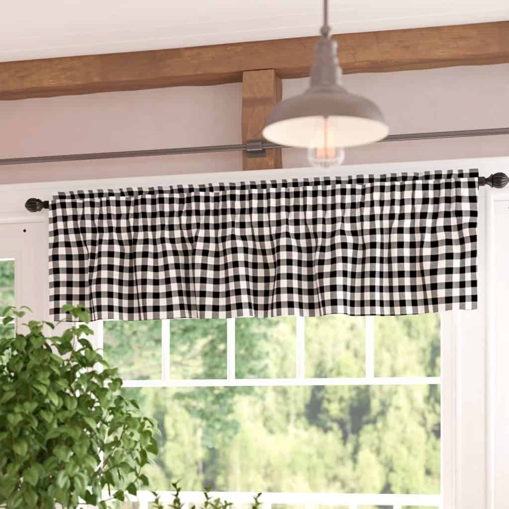 Black and white gingham valance over a window with a view of greenery