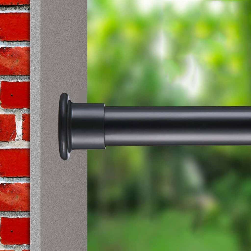 Black tension rod mounted between a brick wall and another surface