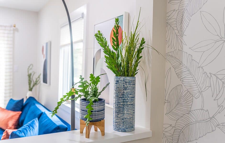 Two vases with greenery on a white surface in a modern interior