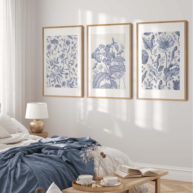 Elegant botanical art prints in natural wood frames add a serene and stylish touch to this cozy bedroom
