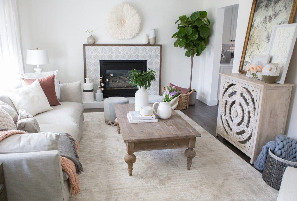 Boho-chic living room with white walls, a circular wall hanging, and a fireplace