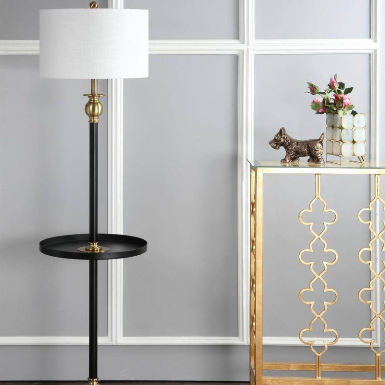 Elegant corner featuring a black and gold floor lamp with a tray, a gold console table, flowers, and a bronze dog figurine