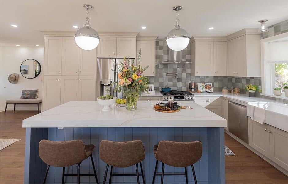 Bright kitchen with large island, beige cabinets, and pendant lighting