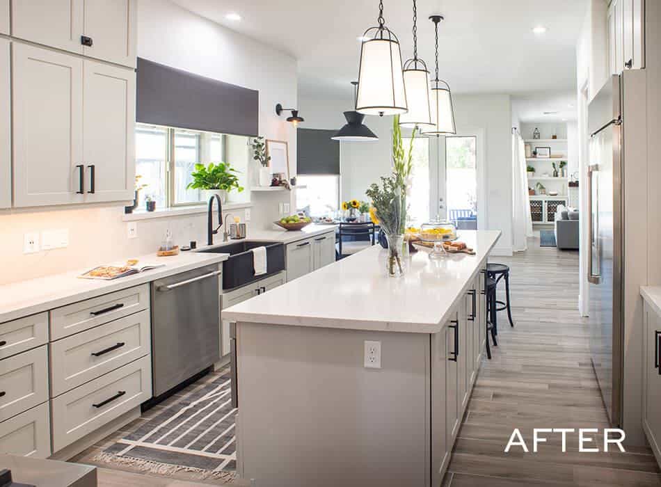 A spacious kitchen with white cabinets, a large island with a white countertop, and a farmhouse sink