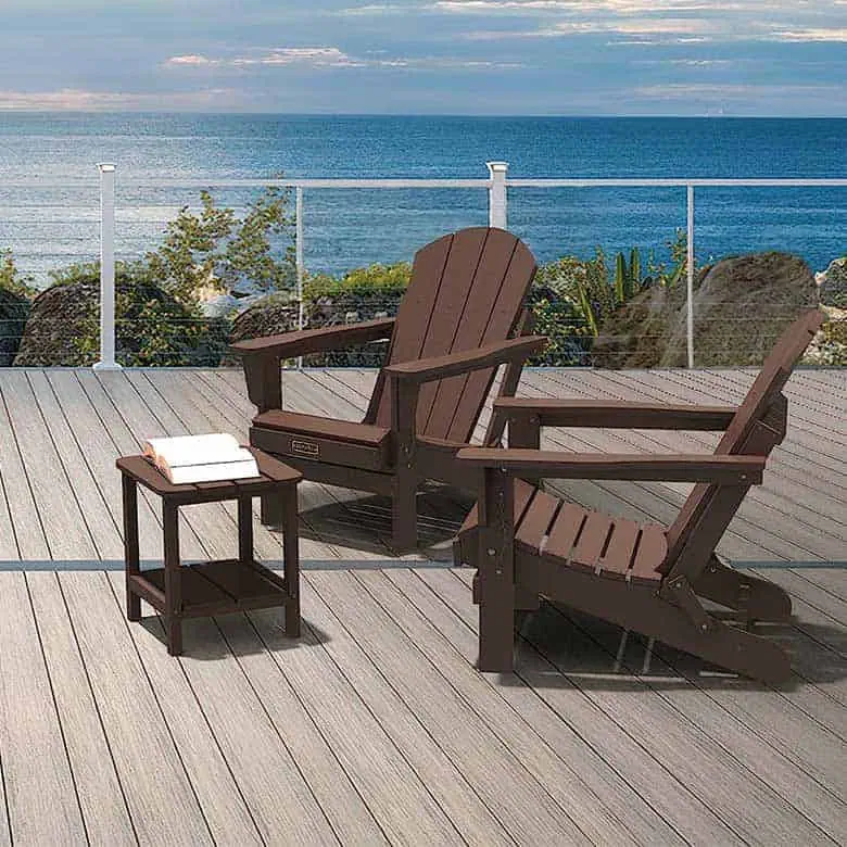 Deck with two brown Adirondack chairs and a small side table overlooking the ocean