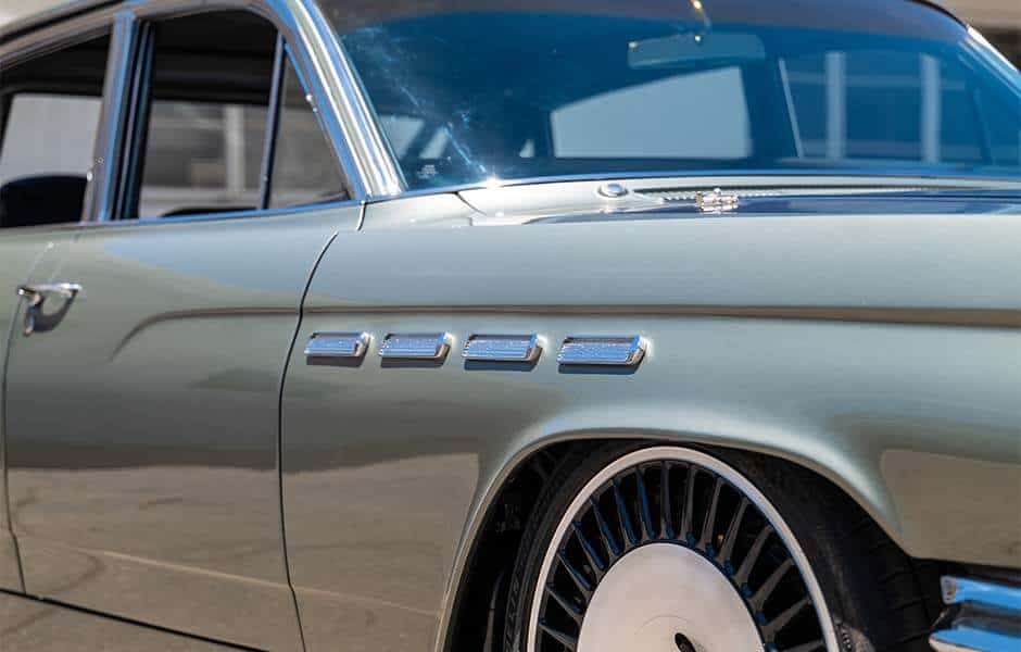 Close-up of a silver Buick Electra with chrome accents and custom wheels
