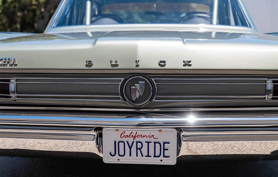 Rear view of vintage Buick with chrome details and personalized "Joyride" license plate