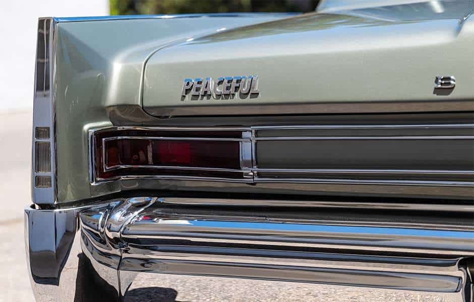 Close-up of vintage car rear with chrome details and "Peaceful" emblem