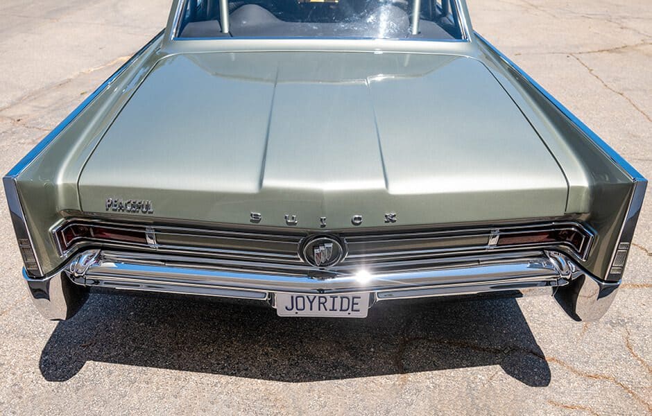 The back of a vintage Buick Wildcat with a custom paint job and a "JOYRIDE" license plate