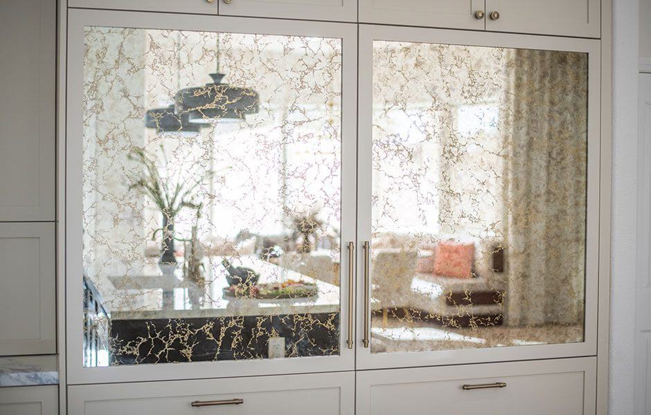 Marble cabinet doors reflecting a furnished room