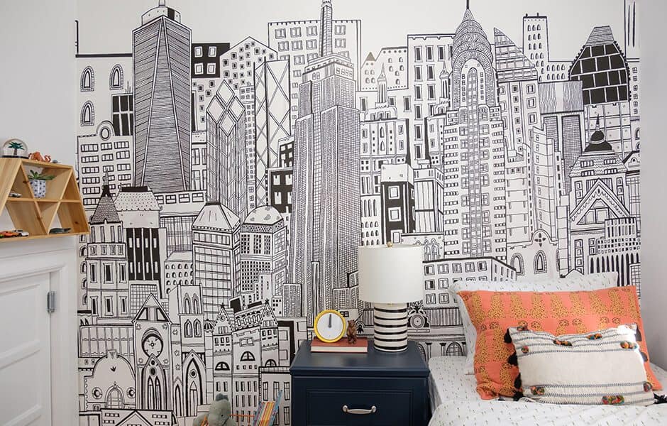 Bedroom with a large mural depicting a cityscape, a small bedside table and a bed