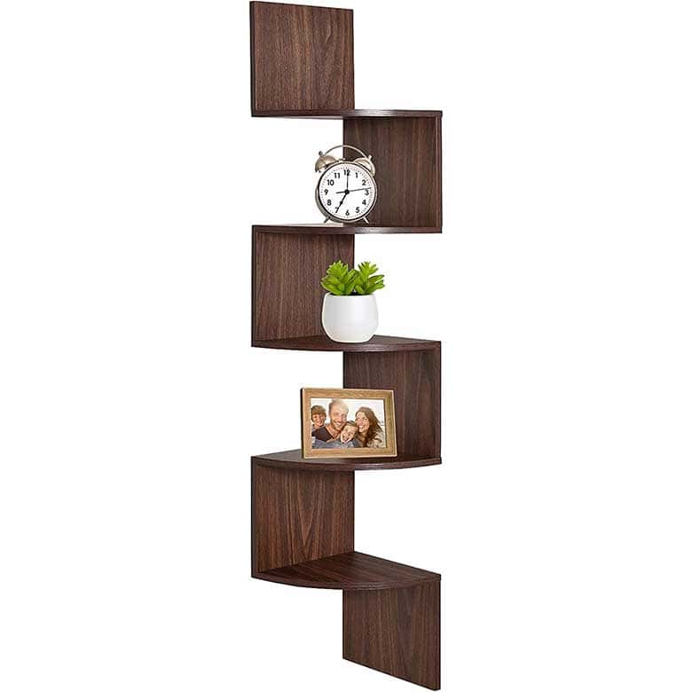 Wooden corner wall shelf with multiple tiers holding a clock, potted plant, and framed photo