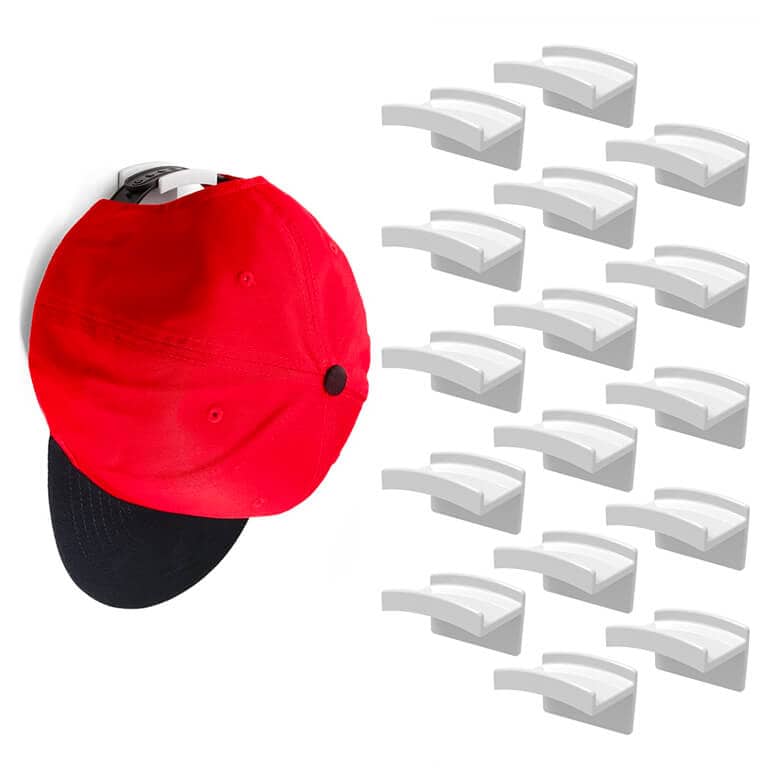 Set of adhesive wall hooks shown holding a red baseball cap
