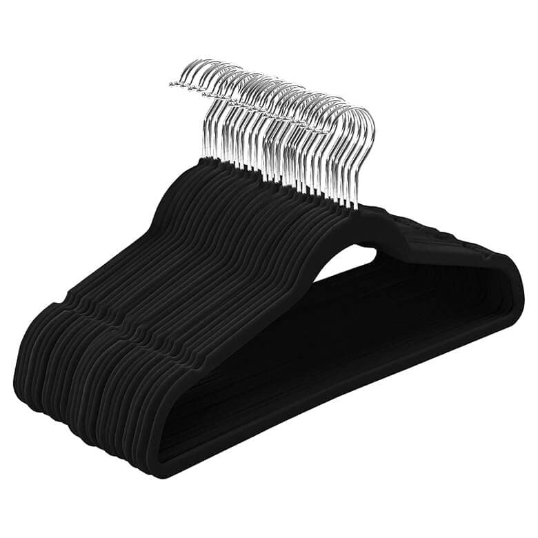 Stack of black velvet hangers with silver metal hooks
