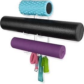 Wall-mounted storage rack holding foam rollers, yoga mat, and resistance bands