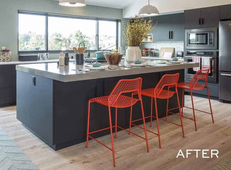 Modern kitchen with dark cabinets, large island, and bright red bar stools
