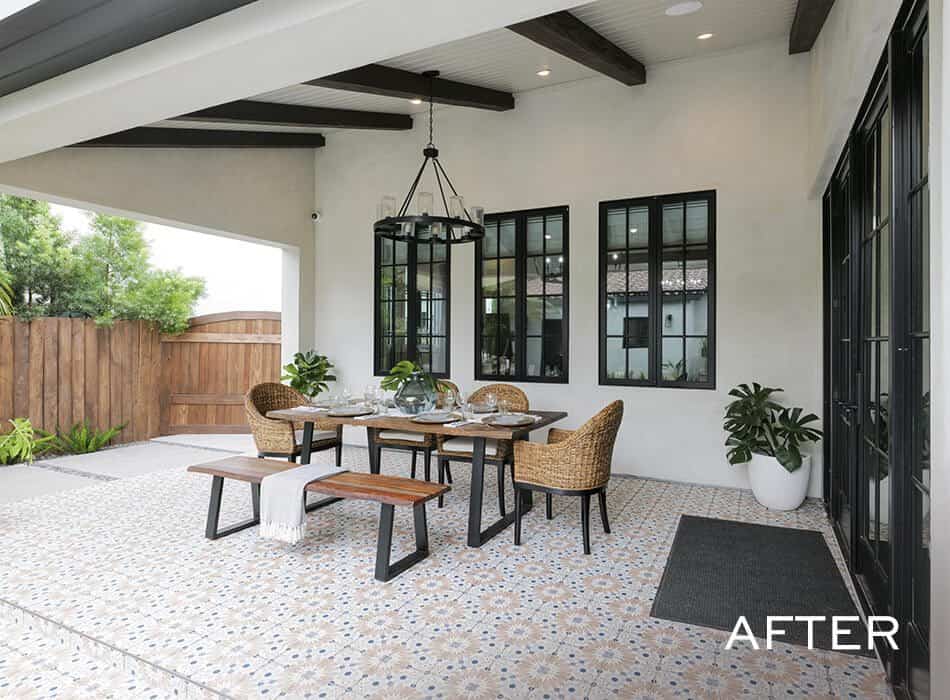 Patio dining area with tiled floor, wooden table, woven chairs, and chandelier