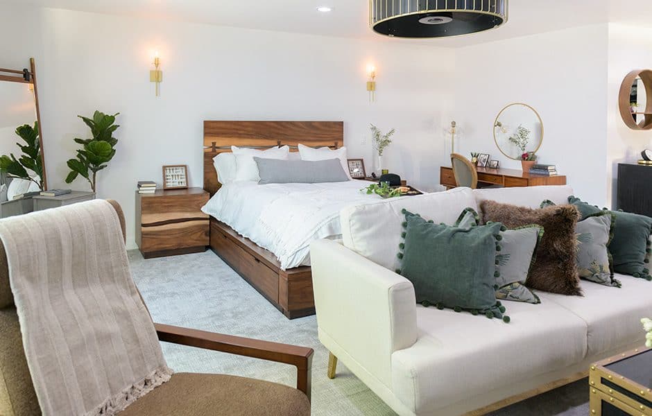 Stylish bedroom with a wooden bed frame, cozy seating, and modern decor