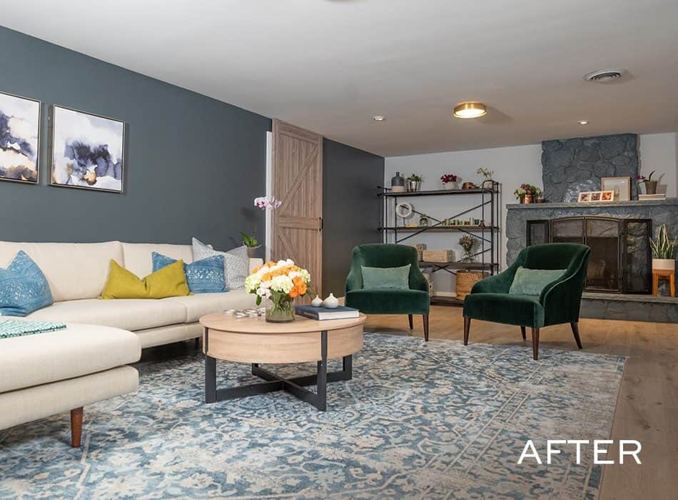 Stylish living room with a sectional sofa, green armchairs, round coffee table, and stone fireplace