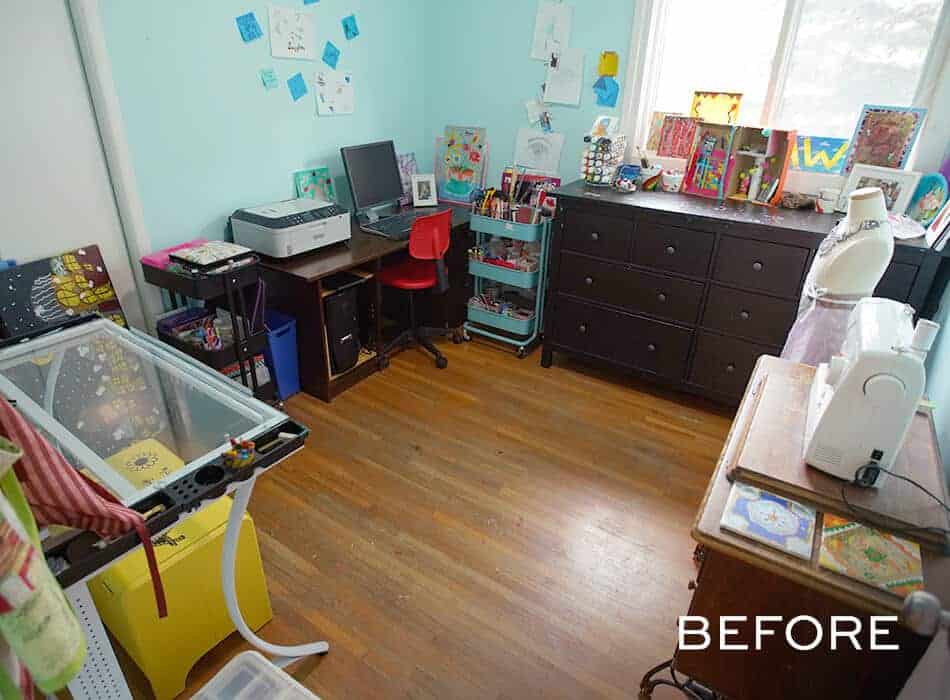 Cluttered craft and sewing room with a desk, printer, sewing machine, art supplies, and a black dresser