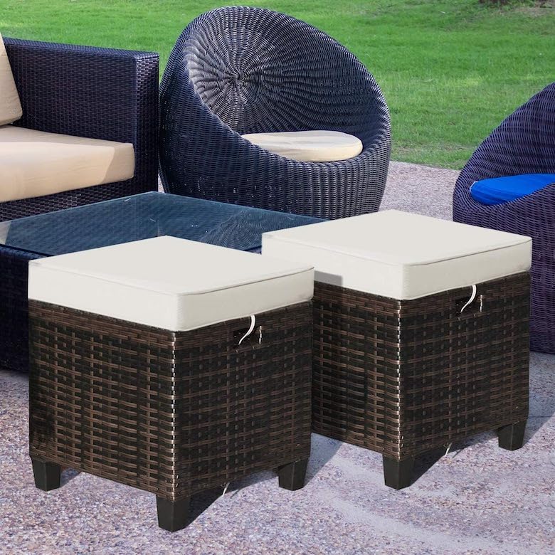 Outdoor wicker furniture set with two cushioned ottomans and a glass-top table