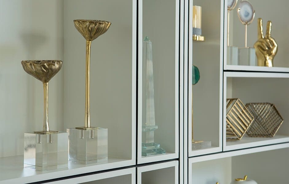 Decorative shelf with gold and glass ornaments displayed in geometric compartments