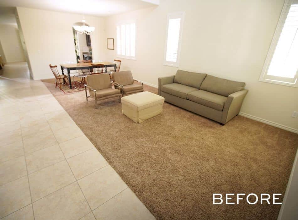 Simple living and dining area with beige carpet, neutral sofa, dining table, and tile flooring
