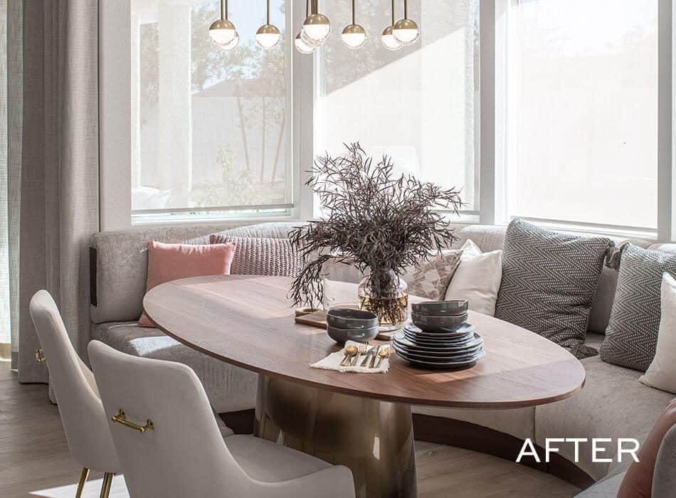 Bright dining area with an oval table, bench seating, decorative lighting, and a centerpiece