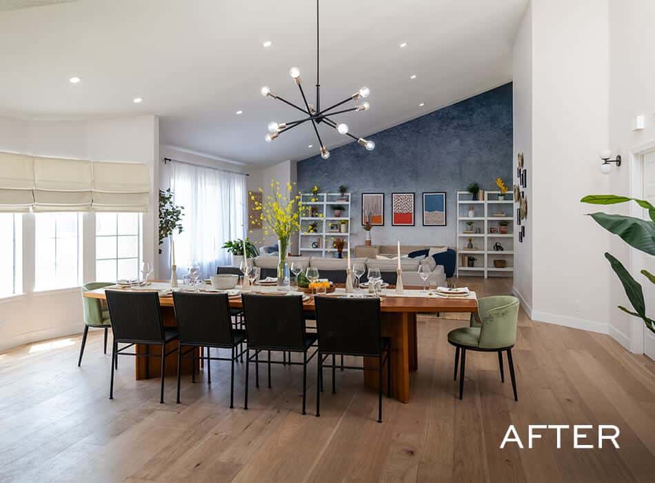Dining room with a wooden table, black chairs, and a blue accent wall