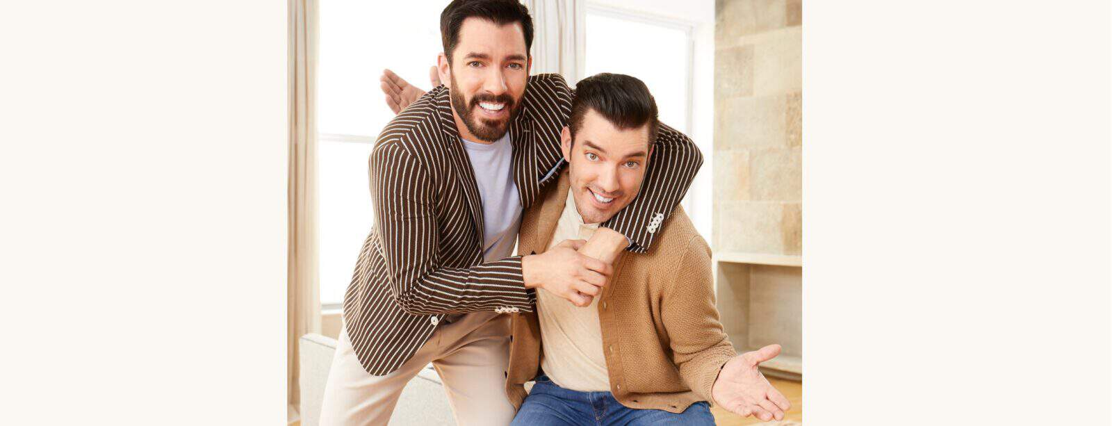 Drew and Jonathan smiling and posing playfully indoors, one with his arm around the other