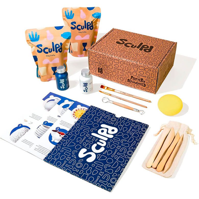 Pottery kit with clay bags, tools, paints, instructions, and branded packaging