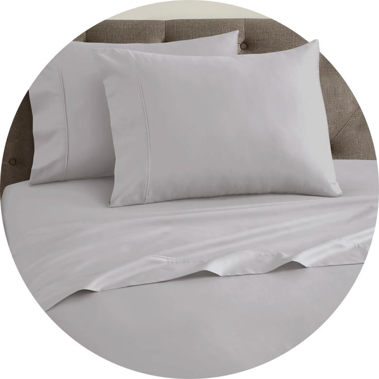 White bed sheet set with matching pillowcases on a bed