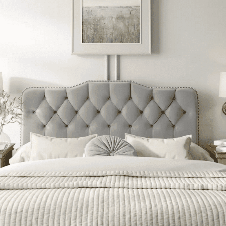 Elegant bedroom with a tufted gray headboard, neutral bedding, and decorative pillows