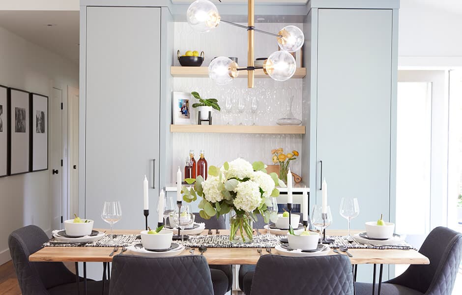 Elegant dining room with a wooden table, black chairs, and a floral centerpiece